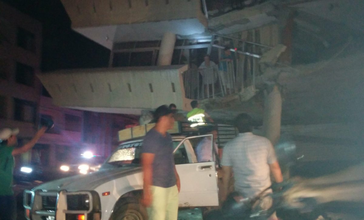 Policías y voluntarios intentan rescatar a una familia de una casa destruida en Portoviejo, la noche del 16 de abril de 2016.