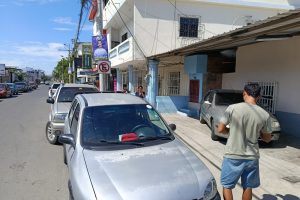 La señal de prohibido estacionar junto a los carros que infringen las señales de tránsito.