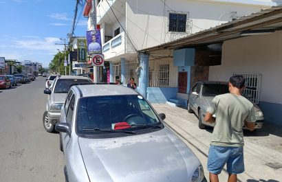 La señal de prohibido estacionar junto a los carros que infringen las señales de tránsito.