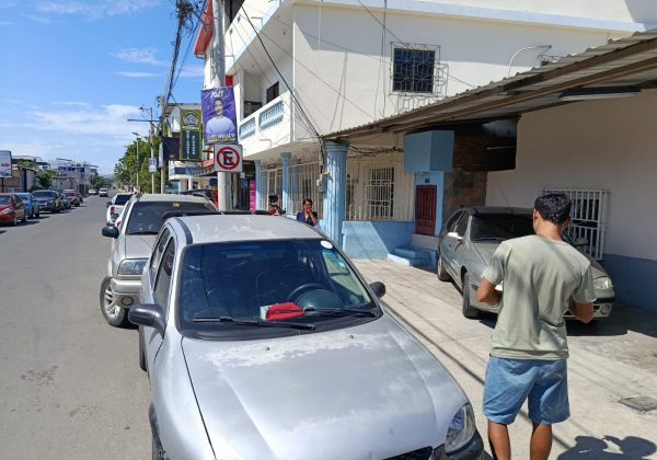La señal de prohibido estacionar junto a los carros que infringen las señales de tránsito.