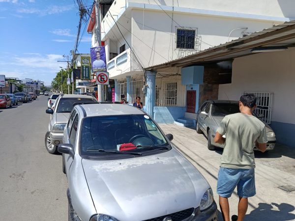 La señal de prohibido estacionar junto a los carros que infringen las señales de tránsito.