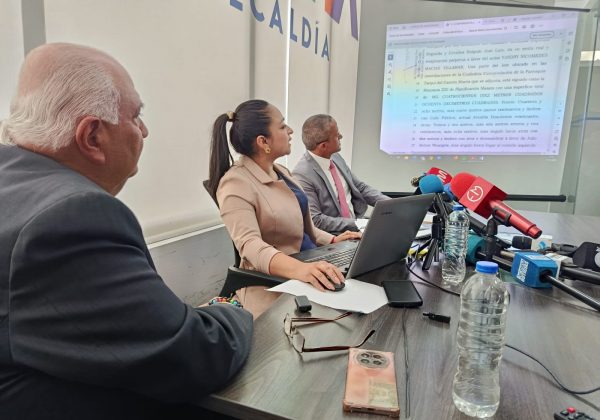 Funcionarios del Registro de la Propiedad mostrando los documentos del bien inmueble durante la rueda de prensa.