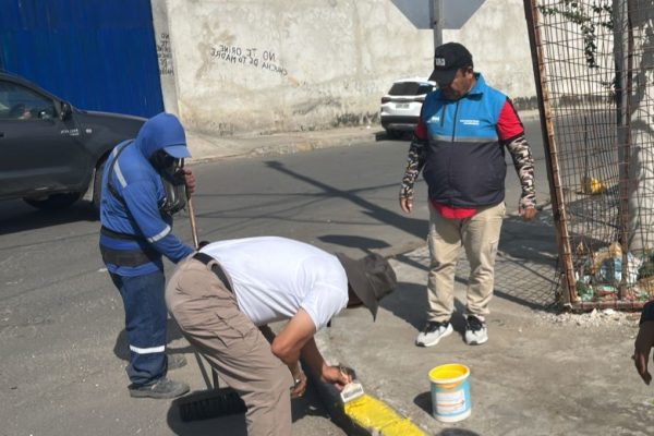 Vecinos de la avenida 108 en Los Esteros mientras pintan los bordillos para mejorar la imagen del sector.