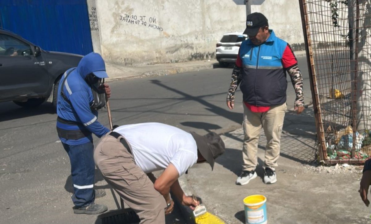 Vecinos de la avenida 108 en Los Esteros mientras pintan los bordillos para mejorar la imagen del sector.