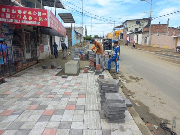 Obreros trabajando en la instalación de adoquines en la calle 321 de la parroquia Eloy Alfaro.